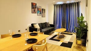 Un salon moderne avec une table à manger pour deux personnes, un canapé et une table basse.