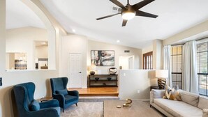 A modern living room with a sofa, two armchairs, a coffee table, and a ceiling fan. - Glendale Paradise | Pool | Pickleball | Putt-Putt (Glendale)