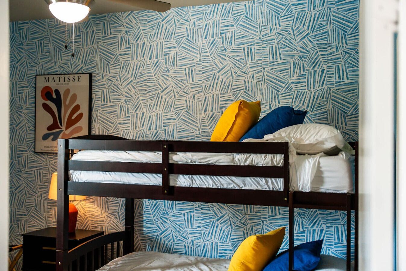 Un letto a castello con una parete decorata e un'opera d'arte incorniciata.