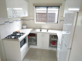 Apartamento standard, 2 quartos | Cozinha privada | Geladeira, micro-ondas, cooktop, talheres/pratos/utensílios de cozinha