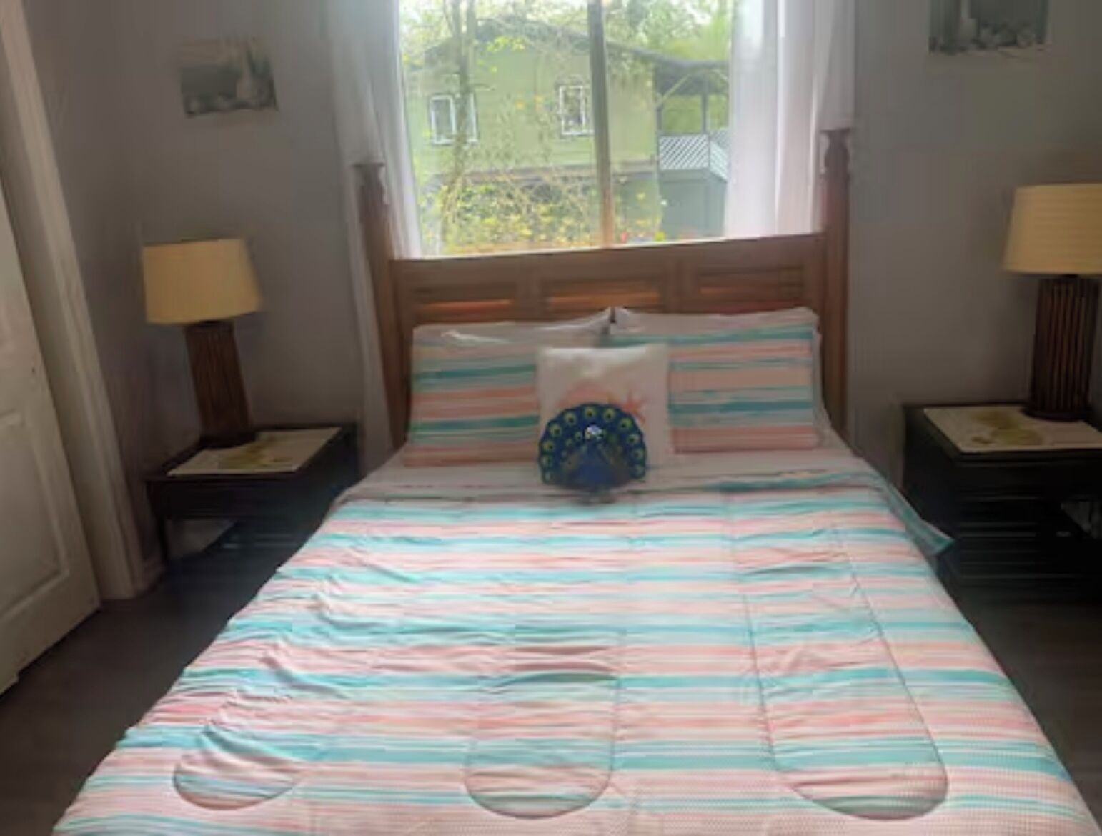 Ein Bett mit gestreifter Bettwäsche, einem Zierkissen und zwei Nachttischlampen.