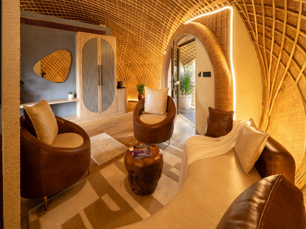 A modern interior with a curved ceiling, leather sofas, a wooden cabinet, and a checkered rug.
