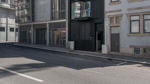 A modern building with a mix of glass and concrete facades, featuring multiple floors and large windows. - GuestReady - Age of Discoveries - Cabral Apt (Porto)