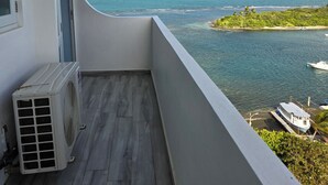 Ein Balkon mit Blick auf das Meer und eine kleine Insel.