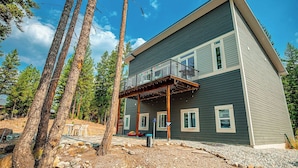 A two-story house with a balcony, surrounded by trees and a gravel driveway. - Lakefront Home. Built 2016. For Remote work, boating, relaxing, hiking. (Marion)