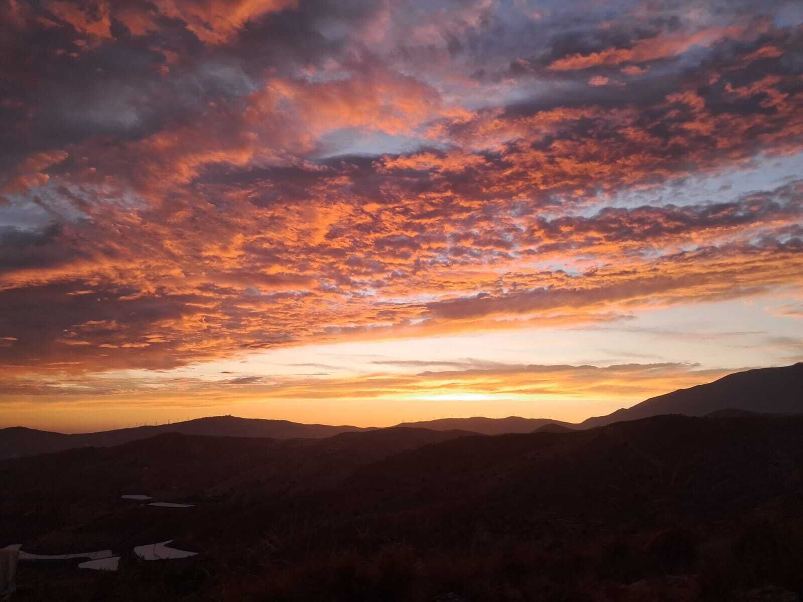Un paisaje montañoso con un atardecer.