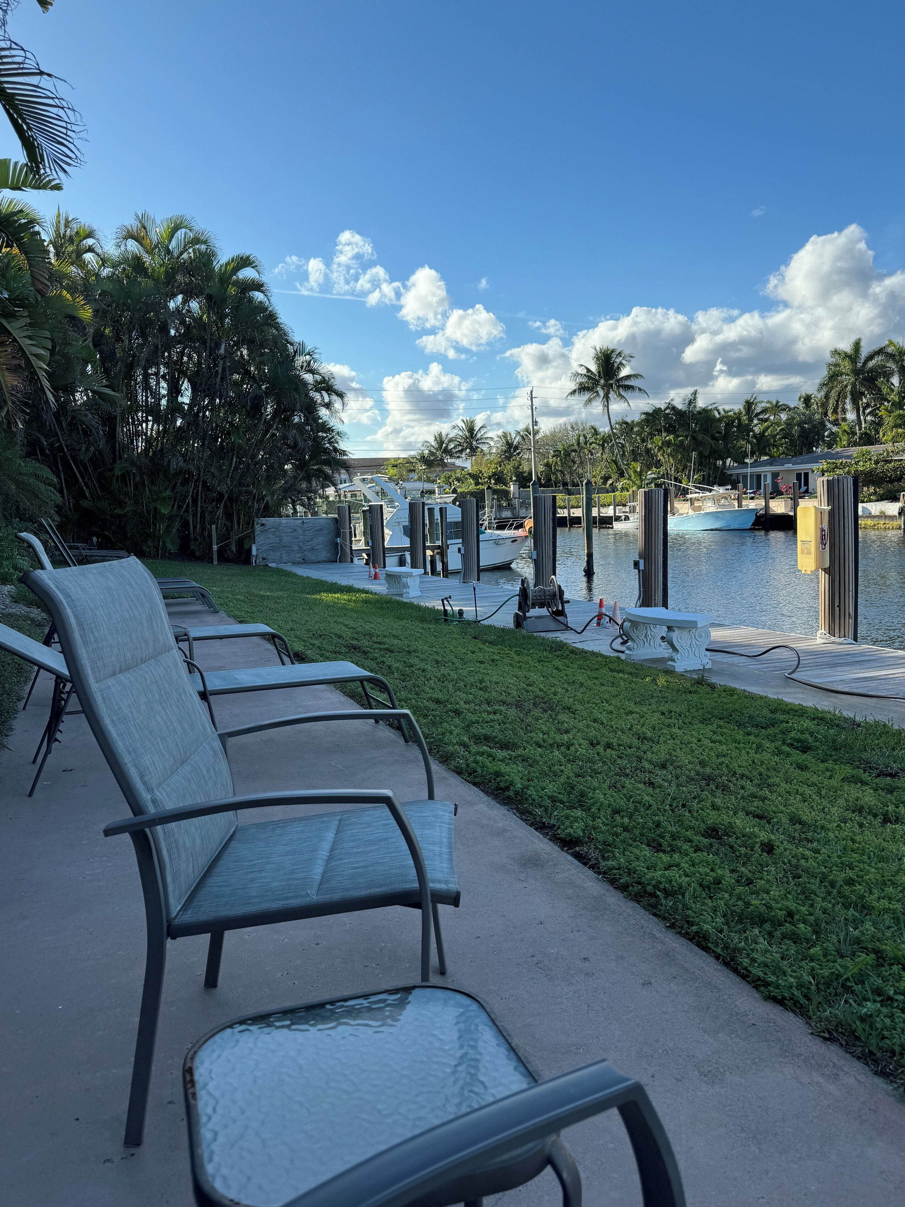 A waterfront area with lounge chairs and a dock.
