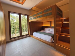 A bunk bed room with a large window, a staircase, and a view of trees. - Leafy Riverbank (Tabanan)