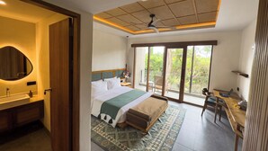 Une chambre à coucher comprenant un lit, un bureau, une chaise, un balcon et un ventilateur de plafond.