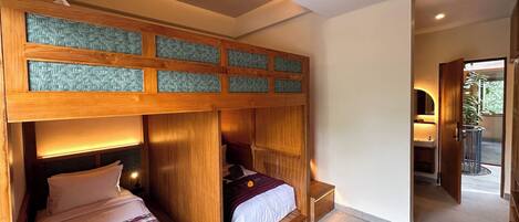 A bedroom with two beds, wooden headboards, and a ceiling fan.