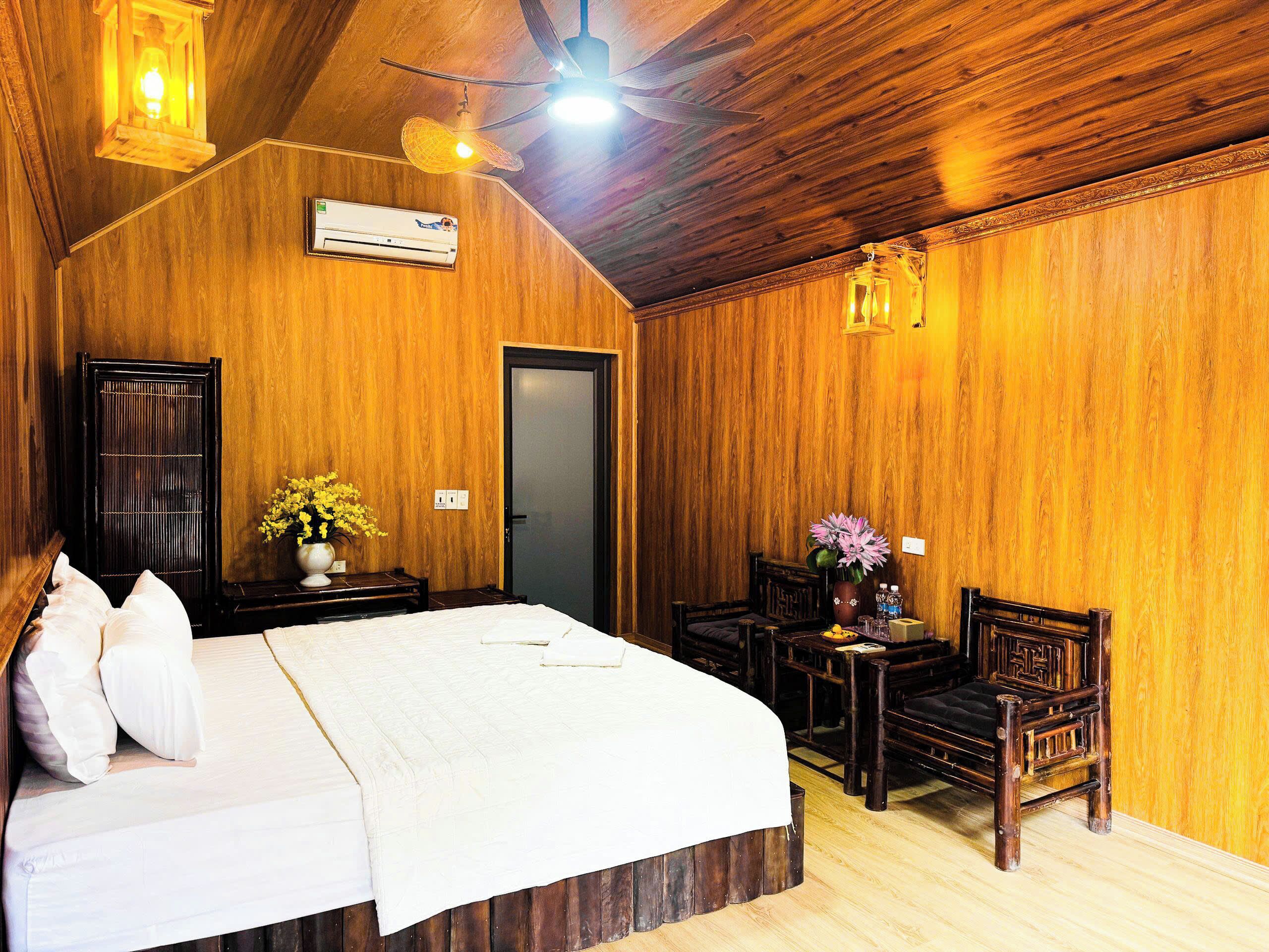 A wooden room with a bed, a desk, and a chair.