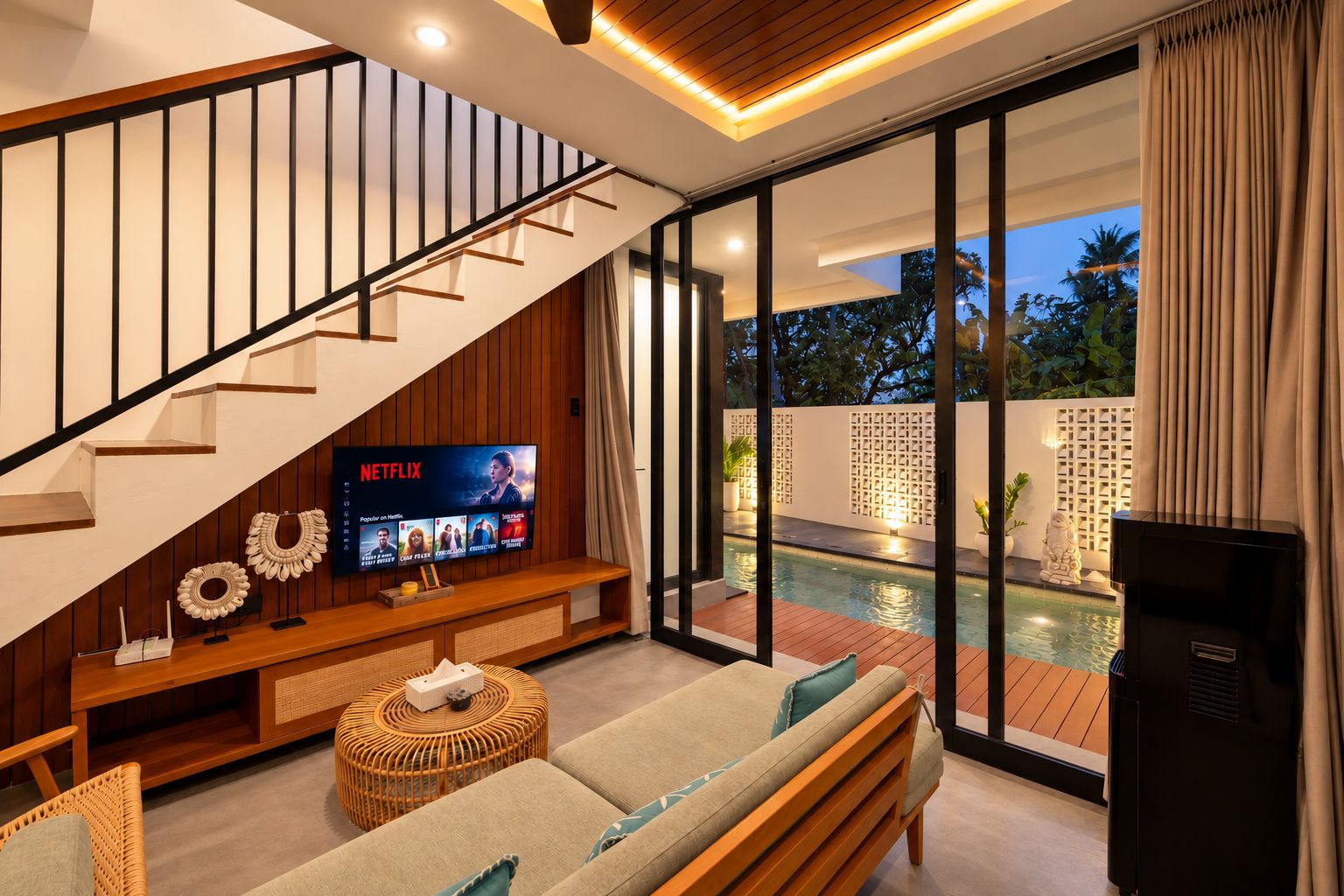 Una sala de estar moderna con escalera, televisor de pantalla plana, piscina y un rincón de descanso acogedor.
