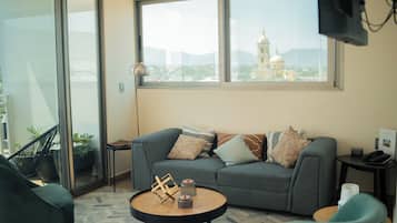 Habitación cuádruple Deluxe, varias camas, para no fumadores, vista a la ciudad | Área de sala de estar