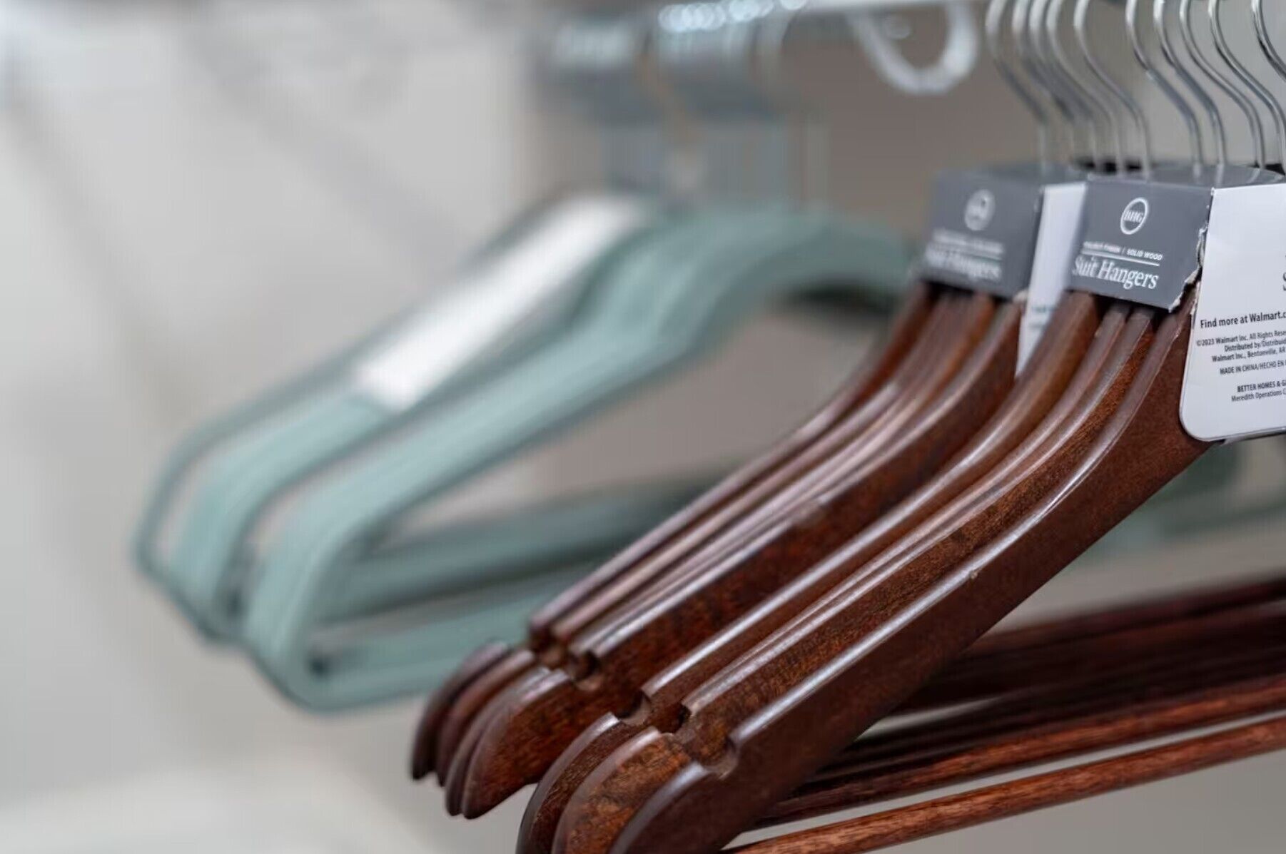 Primer plano de perchas de madera con una etiqueta, probablemente de una tienda.