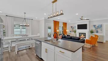 A modern kitchen with white cabinetry, a central island, and pendant lighting.