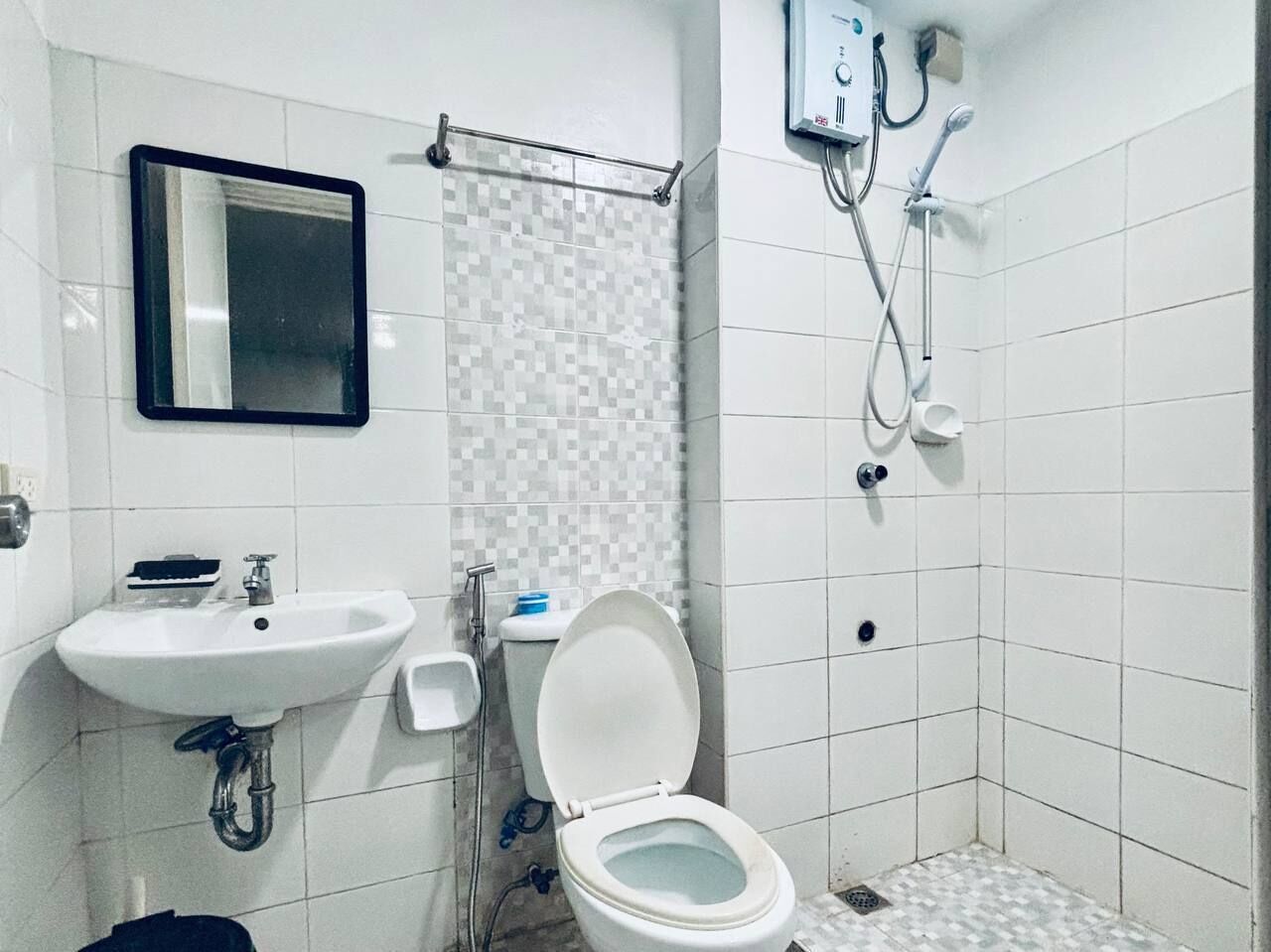 Een badkamer met een wit wastafel, toilet en douche.