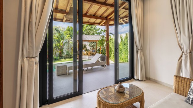 Une chambre moderne dotée de grandes portes-fenêtres coulissantes qui donnent sur un patio extérieur.