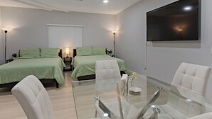 A modern hotel room with two beds, a glass table, and a ceiling fan. - Relax & Unwind - Cozy 1 BR w/ Room for 5 Guests (San Diego)
