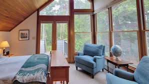 A cozy room with a bed, a desk, a chair, and a globe on a small table.