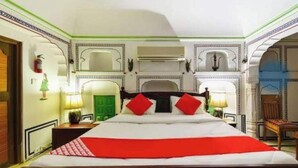 Una habitación de hotel con una cama grande, paneles decorativos en la pared y una puerta verde.