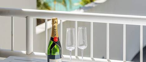 Una botella de champán Moët & Chandon y dos copas sobre una barandilla blanca.