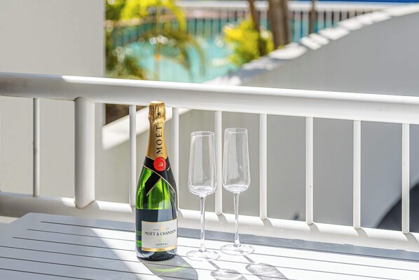 A bottle of Moët & Chandon champagne and two glasses on a white balcony railing.