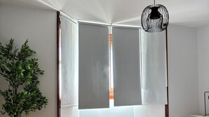 A bedroom with a bed, a potted plant, and a hanging light fixture. - Fuente del Tesoro Apartment (AN)