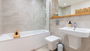 Un baño moderno con bañera, inodoro y lavamanos.