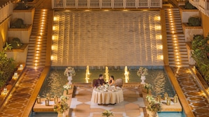 A luxurious indoor dining area with a pool, surrounded by ornate railings and decorative lighting. - Taj Lalit Bagh, Udaipur (Māvli)