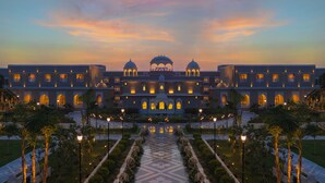 A large, multi-story building with a symmetrical facade, featuring multiple windows and domed structures. - Taj Lalit Bagh, Udaipur (Māvli)