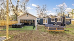 A residential backyard with a wooden deck, a small pool, and two houses. - Renovated 7BR - Gym, Hot Tub, Sauna & Cold Plunge! (Southfield)