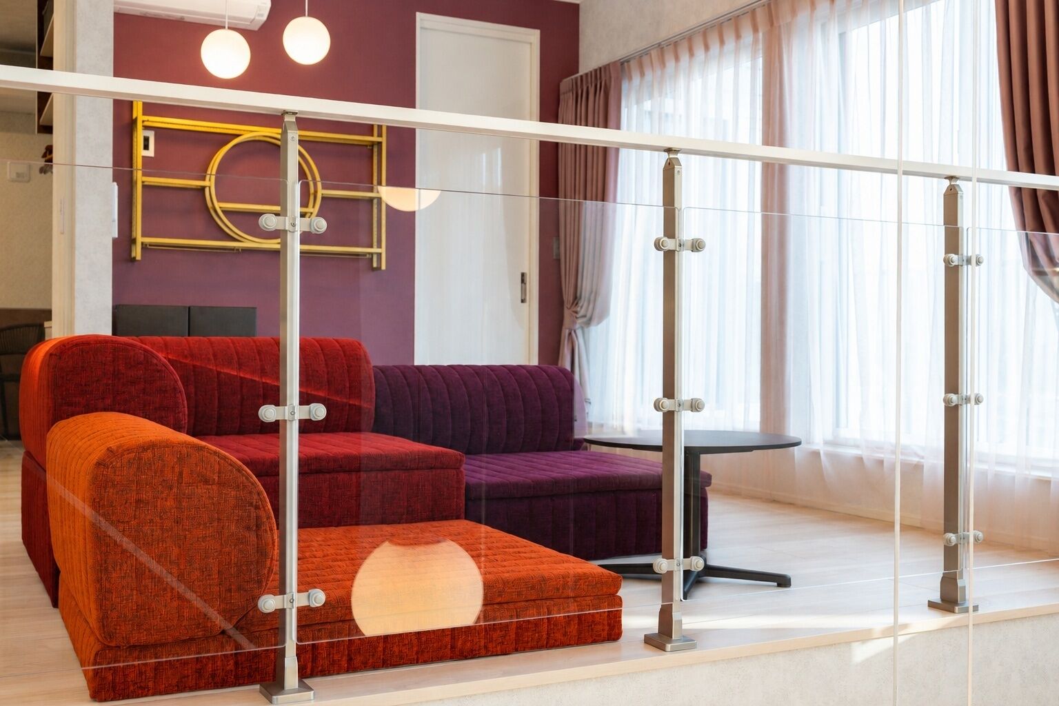 A modern living room with a glass partition, a sofa set, and a table.