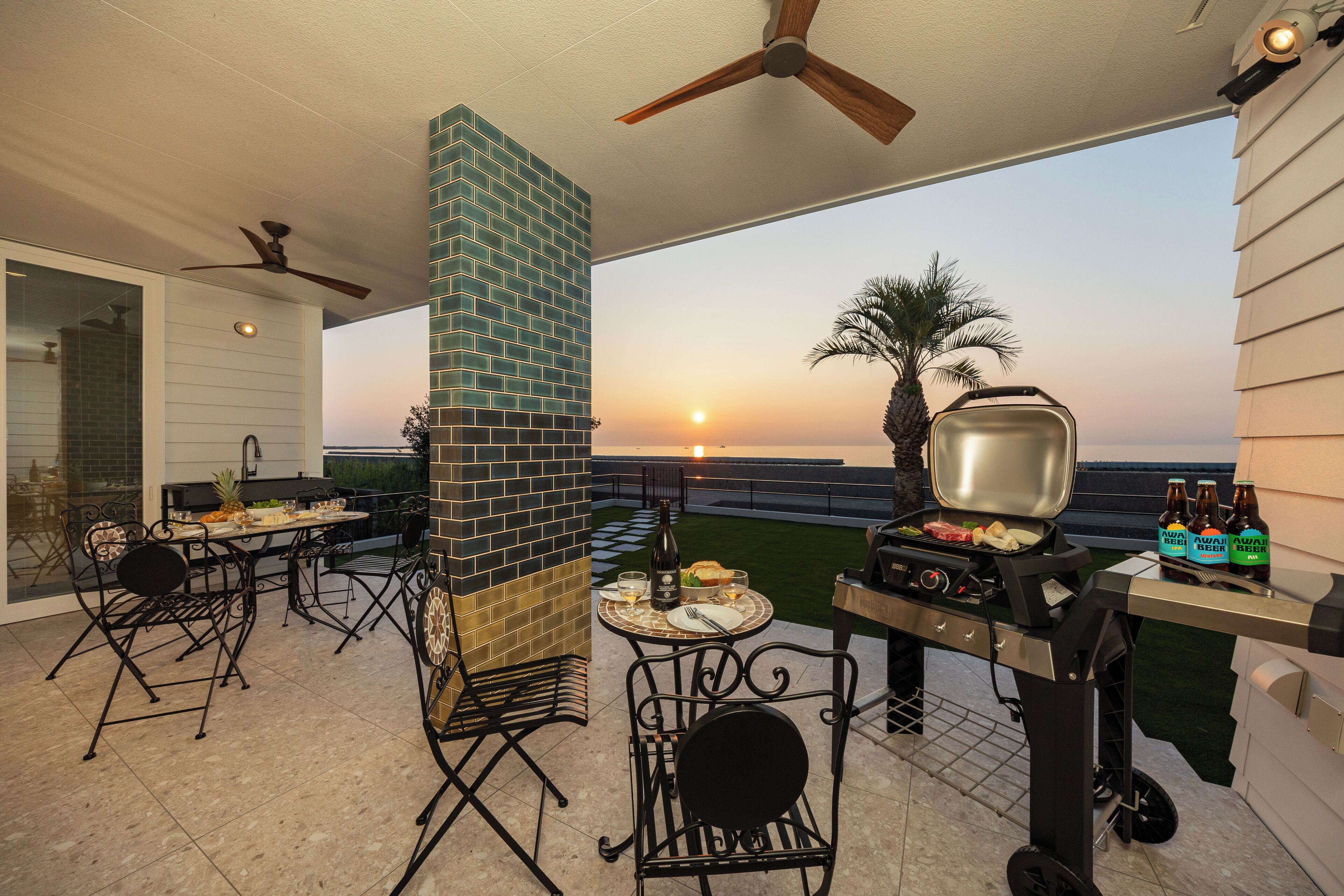 Eine Terrasse im Freien mit einem Ziegelkamin, einem Grill und einem Esstisch.