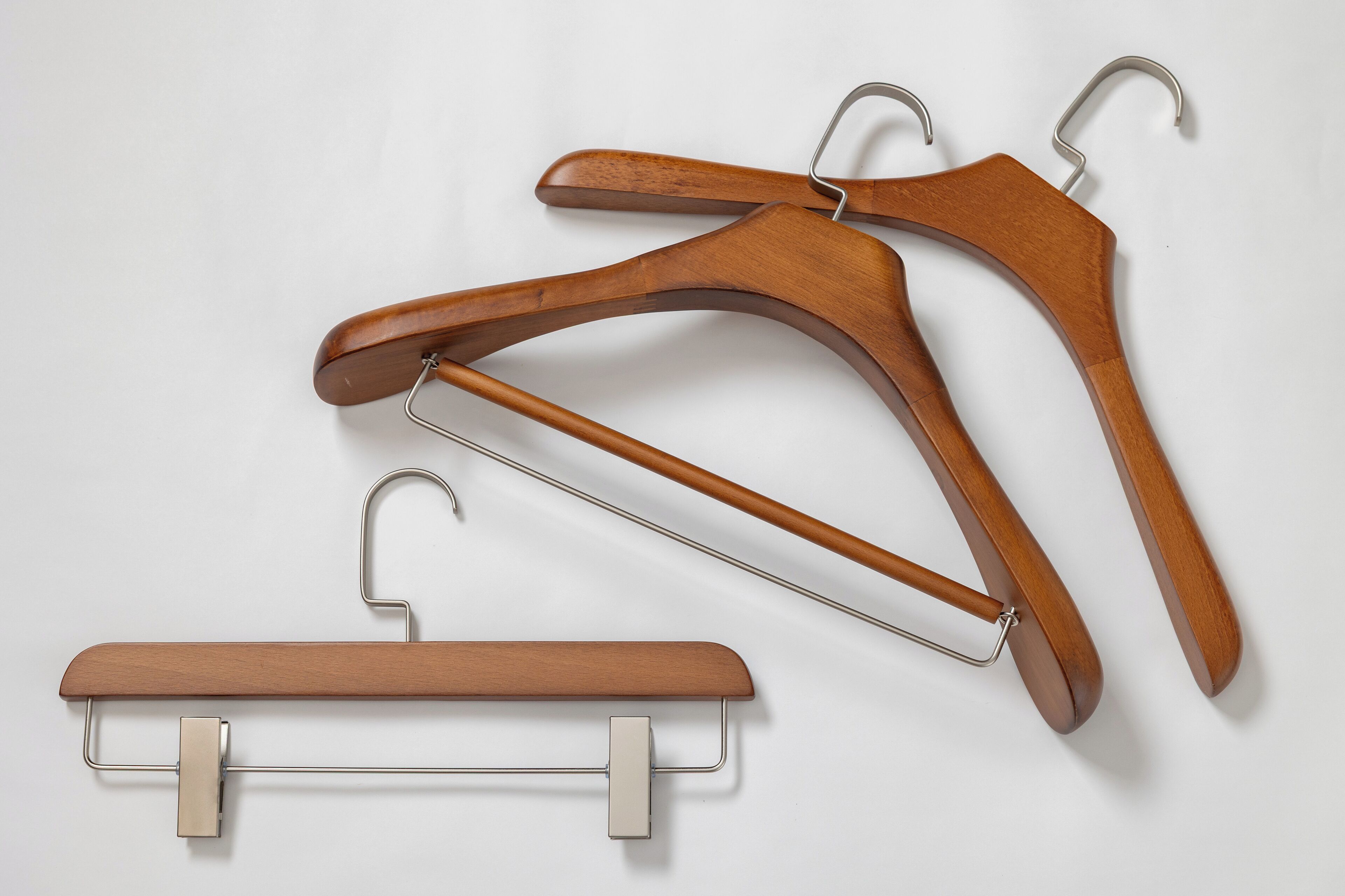 A wooden hanger with a metal clip and a wooden hanger with a metal clip.