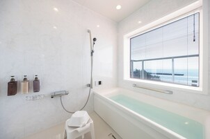 Un baño moderno con bañera, ducha y ventana con vistas.