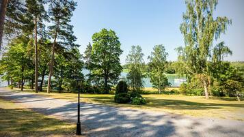 A park with a gravel path, trees, and a lamp post.