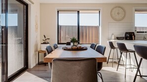 Una cocina moderna con una gran mesa de comedor, taburetes de bar y una encimera.