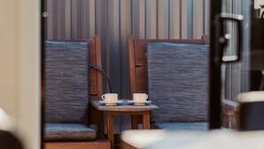 Un espacio al aire libre acogedor con muebles de madera y una pequeña mesa con tazas.
