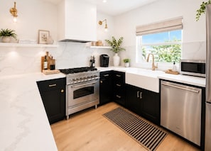 A modern kitchen with a stove, oven, microwave, and dishwasher.
