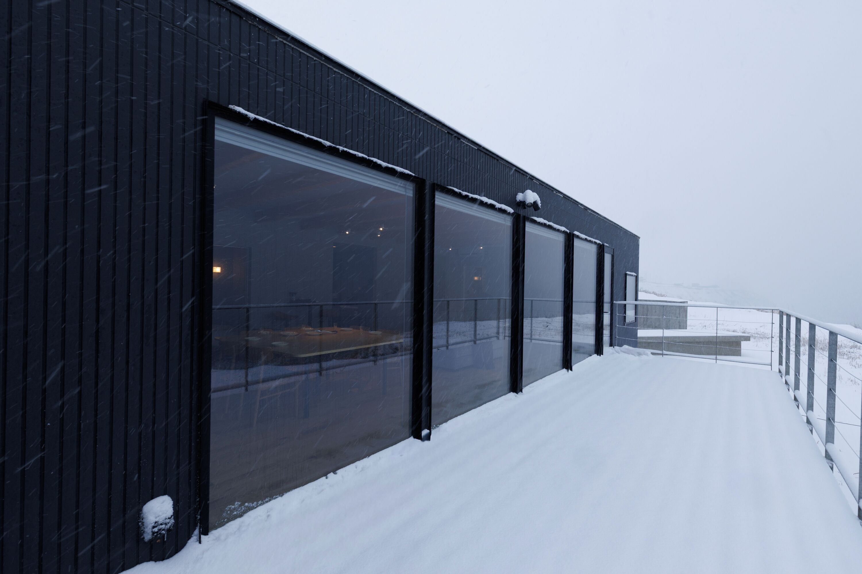 A modern building with large windows and a snow-covered exterior.