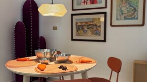 A dining area with a round table, metal bowls, orange placemats, and red chairs. - Shelter among plants in Tampiquito 2br, 3bed, 2ba (San Pedro Garza García)