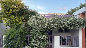 A house with a white exterior, a purple gate, and a tree with white flowers. - Shelter among plants in Tampiquito 2br, 3bed, 2ba (San Pedro Garza García)
