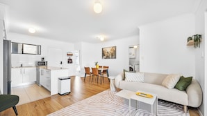 A modern apartment with a kitchen, dining area, and living room. - Stylish 2BR With Wi-fi 100 Mbps TV big 75 Inch (Perth)
