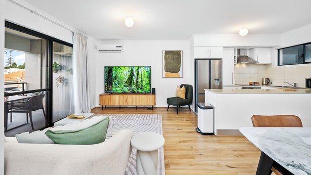 A modern apartment with a living area, kitchen, and dining space. - Stylish 2BR With Wi-fi 100 Mbps TV big 75 Inch (Perth)