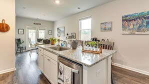 Una cocina amplia con encimera de granito, electrodomésticos de acero inoxidable y vistas al comedor.