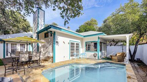 A backyard with a swimming pool, patio furniture, and a covered seating area. - Private Heated Pool: Quiet Getaway in San Antonio (San Antonio)
