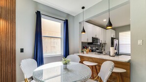 Une cuisine moderne avec des meubles blancs, un four à micro-ondes et un réfrigérateur.