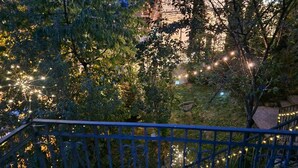 Una escalera con barandilla azul, rodeada de árboles y luces de cadena.