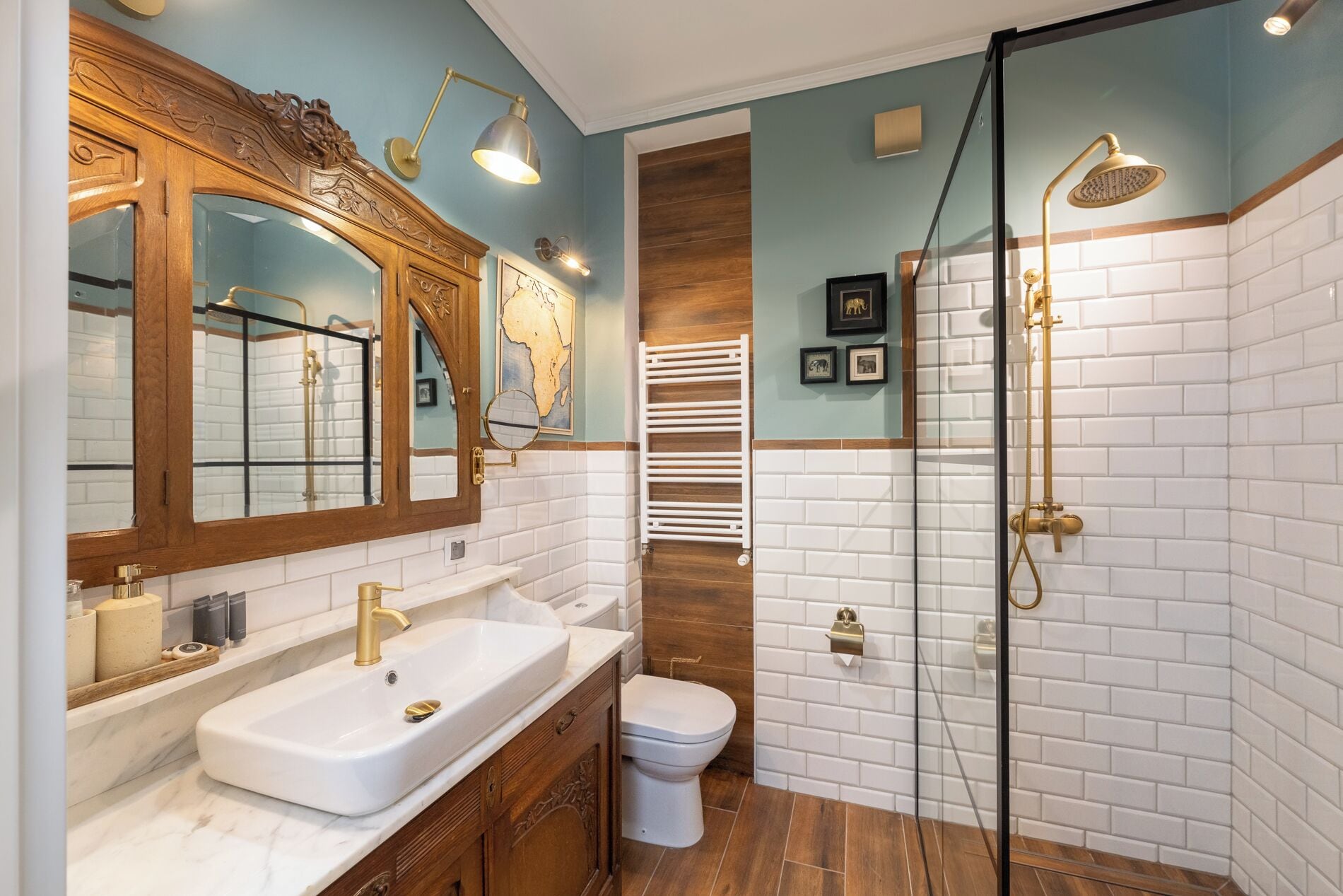 Ein Badezimmer mit weißem Waschbecken, Toilette, Dusche mit Glastür und Holzwaschtisch.