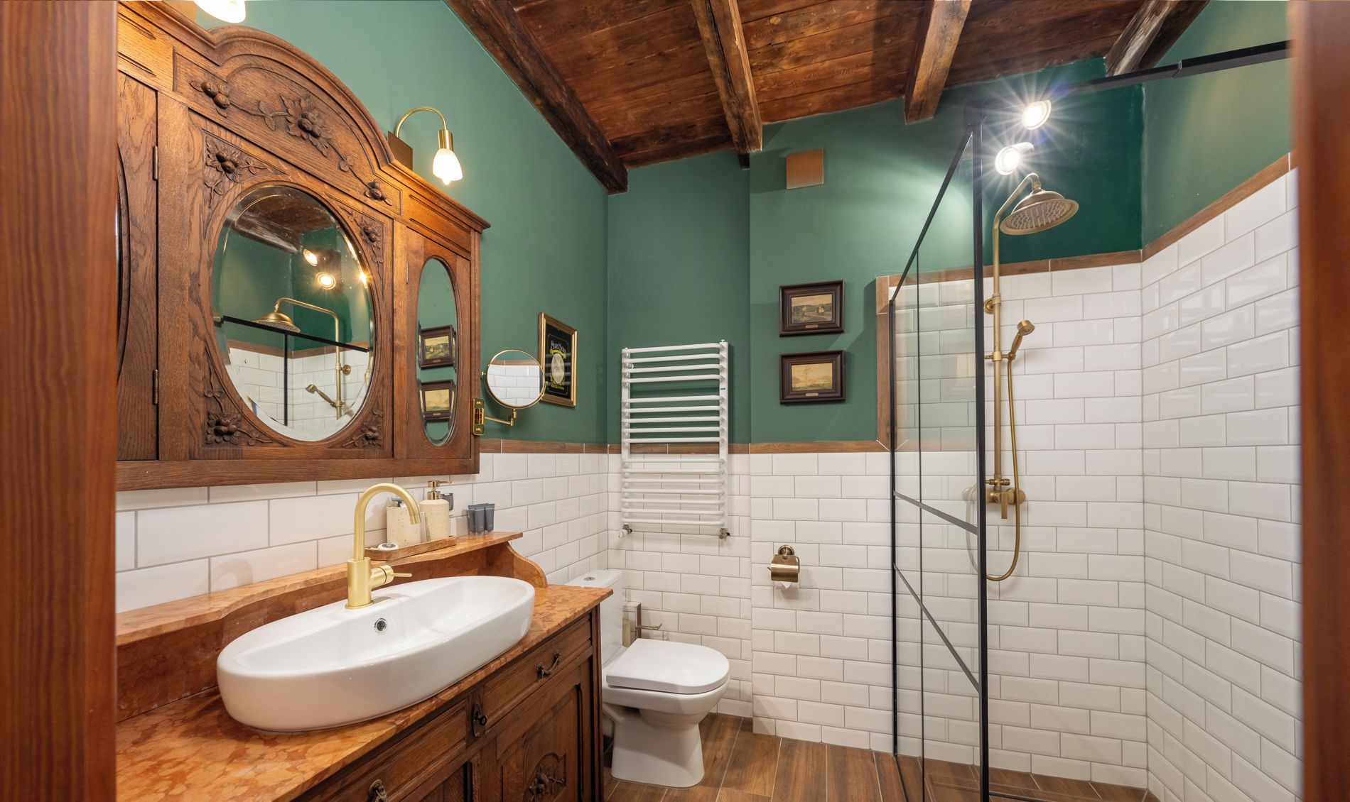 Ein Badezimmer mit einem Holzkosmetikschrank, einem weißen Waschbecken, einer Toilette und einer Duschkabine.